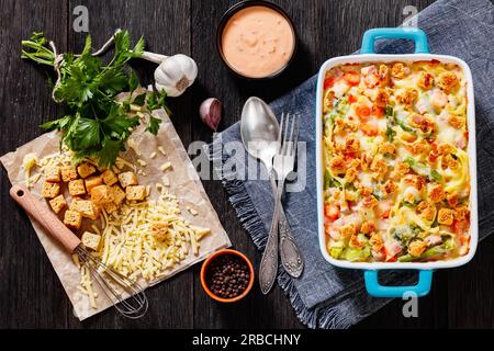 Schinken- und Nudelauflauf mit Eiernudeln, gehacktem Schinken, Karotten, Brokkoli, Spargel und einer reichen und cremigen Sauce, garniert mit Croutons in der Backform, Stockfoto