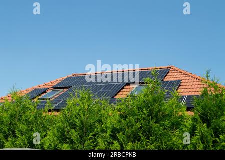 Hausdach mit Photovoltaikmodulen. Historisches Bauernhaus mit modernen Sonnenkollektoren auf Dach und Wand Hochwertiges Foto Stockfoto