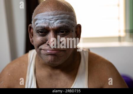 Ein fetter Mann mit einem komischen Gesicht. Der Mann macht eine Vielzahl von Ausdrücken, von albernem Grinsen bis zu überraschtem Aussehen. Stockfoto