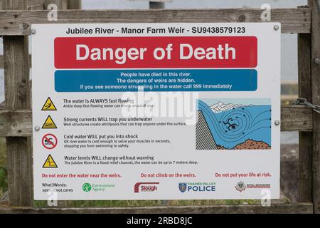 Dorney, Buckinghamshire, Großbritannien. 8. Juli 2023. Ein Schild mit Todesgefahr am Jubilee River in Dorney, Buckinghamshire. Im Anschluss an die RLSS UK Ertrinkungsvorbeugungswoche im vergangenen Monat werden die Teams von Windsor & Maidenhead Neighbourhood den ganzen Sommer über Hotspots patrouillieren, in denen Jugendliche als Grabstein in den Jubilee River bekannt sind. Viele Jugendliche wissen nicht, dass sie beim Springen in kaltes Wasser einen Herzstillstand bekommen können, und es gibt versteckte Gefahren im Wasser. Die Themse ist auch bekannt für die Verschmutzung des Jubilee River. Kredit: Maureen McLean/Alamy Live News Stockfoto