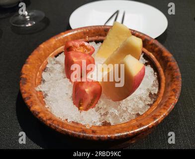 Frisch geschnittene Äpfel und Tomaten auf dem Eis auf dem Teller Stockfoto