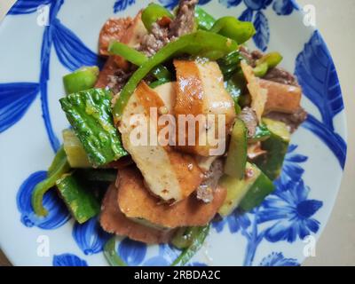 Bohnenquak und grünes Gemüse mit frischem Rindfleisch auf dem blauen Teller Stockfoto