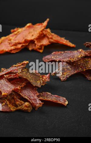 Verschiedene Arten von Trockenfleisch auf schwarzem Hintergrund Stockfoto