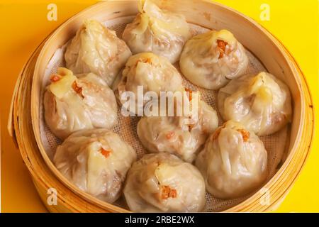 JAKOBSMUSCHELN SUI MAI mit Schweinefleisch und Garnelen，yumcha, Dim Sum, in Hongkong gedünstetes siew Mai Fleischklößchen mit Wantonhaut und Rogen in Bambuskorb asiatisches Dimmfleisch Stockfoto