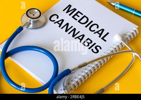 Medizinisches Stethoskop, weißes Notizbuch mit der Aufschrift Medizinischer Cannabis, schöner gelber Hintergrund, die Verwendung von Cannabis und Marihuana in der Medizin Stockfoto