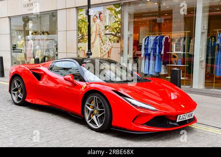 London, England, Vereinigtes Königreich - 27. Juni 2023: Supercar Ferrari F8 Spyder parkt auf einer Straße vor Designerläden im Zentrum Londons. Stockfoto