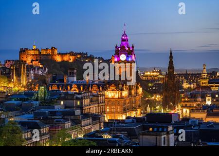 Skyline von Edinburgh bei Nacht in Schottland, Großbritannien. Abendliche Stadtlandschaft mit Edinburgh Castle, dem Uhrenturm des Balmoral Hotels und dem Scott Monument. Stockfoto