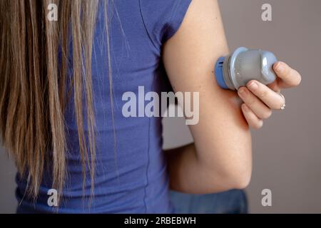 Nahaufnahme eines Mädchens, das einen Blutzuckermessfleck auf ihren Arm aufgesetzt hat Stockfoto