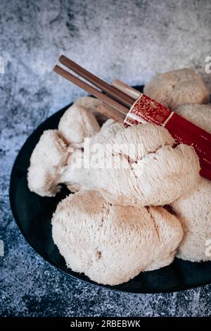 Hericium erinaceus oder Löwen-Mähne-Pilze mit chinesischen Stäbchen. Medizinisches Pilzkonzept Stockfoto