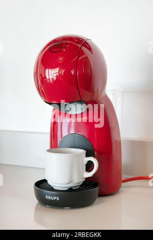 Nescafe Dolce Gusto Krups Kaffeepadmaschine in roter Farbe auf einem Küchentisch, der ein vorverpacktes Kaffeekapselsystem verwendet, um das Heißgetränk herzustellen Stockfoto