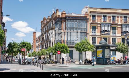 Gebäude und Bewohner, die durch das historische und lebhafte Viertel auf der anderen Seite des Guadalquivir River in Triana, Sevilla, Spanien, fahren Stockfoto