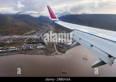 Foto vom Kabinenfenster eines Fluges einer norwegischen Fluggesellschaft, der am Flughafen Longyearbyen an Land geht Stockfoto