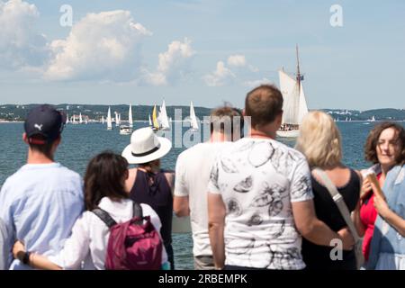 Danzig, Polen. 09. Juli 2023 Besucher am Brzezno Pier und am Strand in der Danzig-Bucht genießen die Schiffsparade des Baltic Sail Maritime Festivals. Die Stadt Danzig veranstaltet zum 27. Mal das Baltic Sail Heritage Segelfestival mit Teilnehmern aus allen Ostseeanrainerstaaten. Die Rallye steht traditionell allen Schiffen offen, einschließlich Touristenjachten, Schneidern und Motorbooten. Das Hauptprogramm der Veranstaltung am Sonntag findet traditionell in der Danziger Bucht statt, wo Tausende von Besuchern, Touristen und Einheimischen das Geschehen genießen können. Kredit: Ognyan Yosifov/Alamy Live News Stockfoto