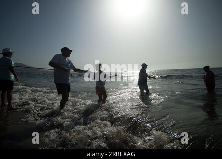 Malaga, Spanien. 09. Juli 2023. Einheimische werden gesehen, wie sie Fische mit einem Netz fangen, während er an der Ausstellung „La Tirada del Copo“ am Strand von Los Boliches teilnimmt. Jedes Jahr feiern die Einheimischen in Fuengirola eine alte Fischereitradition, bekannt als „La Tirada del Copo“, um die Fähigkeiten und den Handel von Seeleuten und Fischern beim Fang von Fischen im Meer zu demonstrieren. Wie es die Tradition vorschreibt, werfen Seeleute während der „La Tirada del Copo“ Netze ins Meer, die einen Halbkreis bilden, während andere die Netze zum Strand ziehen, um alle Fische zu fangen. Kredit: SOPA Images Limited/Alamy Live News Stockfoto