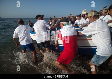 Malaga, Spanien. 09. Juli 2023. Einheimische werden gesehen, wie sie ein Fischerboot („jabega“) in Richtung Meer schieben, während sie an der Ausstellung „La Tirada del Copo“ am Strand von Los Boliches teilnehmen. Jedes Jahr feiern die Einheimischen in Fuengirola eine alte Fischereitradition, bekannt als „La Tirada del Copo“, um die Fähigkeiten und den Handel von Seeleuten und Fischern beim Fang von Fischen im Meer zu demonstrieren. Wie es die Tradition vorschreibt, werfen Seeleute während der „La Tirada del Copo“ Netze ins Meer, die einen Halbkreis bilden, während andere die Netze zum Strand ziehen, um alle Fische zu fangen. Kredit: SOPA Images Limited/Alamy Live News Stockfoto