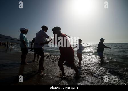 Malaga, Spanien. 09. Juli 2023. Ein Einheimischer, der Fische mit einem Netz fangen kann, während er an der Ausstellung „La Tirada del Copo“ am Strand von Los Boliches teilnimmt. Jedes Jahr feiern die Einheimischen in Fuengirola eine alte Fischereitradition, bekannt als „La Tirada del Copo“, um die Fähigkeiten und den Handel von Seeleuten und Fischern beim Fang von Fischen im Meer zu demonstrieren. Wie es die Tradition vorschreibt, werfen Seeleute während der „La Tirada del Copo“ Netze ins Meer, die einen Halbkreis bilden, während andere die Netze zum Strand ziehen, um alle Fische zu fangen. Kredit: SOPA Images Limited/Alamy Live News Stockfoto