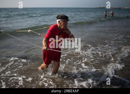 Malaga, Spanien. 09. Juli 2023. Ein Einheimischer, der Fische mit einem Netz fangen kann, während er an der Ausstellung „La Tirada del Copo“ am Strand von Los Boliches teilnimmt. Jedes Jahr feiern die Einheimischen in Fuengirola eine alte Fischereitradition, bekannt als „La Tirada del Copo“, um die Fähigkeiten und den Handel von Seeleuten und Fischern beim Fang von Fischen im Meer zu demonstrieren. Wie es die Tradition vorschreibt, werfen Seeleute während der „La Tirada del Copo“ Netze ins Meer, die einen Halbkreis bilden, während andere die Netze zum Strand ziehen, um alle Fische zu fangen. Kredit: SOPA Images Limited/Alamy Live News Stockfoto