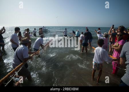 Malaga, Spanien. 09. Juli 2023. Die Einheimischen werden bei der Teilnahme an der Ausstellung „La Tirada del Copo“ am Strand von Los Boliches mit großen Netzen gesehen, um Fische zu fangen. Jedes Jahr feiern die Einheimischen in Fuengirola eine alte Fischereitradition, bekannt als „La Tirada del Copo“, um die Fähigkeiten und den Handel von Seeleuten und Fischern beim Fang von Fischen im Meer zu demonstrieren. Wie es die Tradition vorschreibt, werfen Seeleute während der „La Tirada del Copo“ Netze ins Meer, die einen Halbkreis bilden, während andere die Netze zum Strand ziehen, um alle Fische zu fangen. Kredit: SOPA Images Limited/Alamy Live News Stockfoto