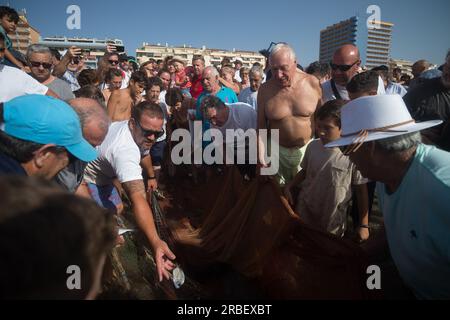 Malaga, Spanien. 09. Juli 2023. Die Einheimischen werfen Fische ins Wasser, während sie an der Ausstellung „La Tirada del Copo“ am Strand Los Boliches teilnehmen. Jedes Jahr feiern die Einheimischen in Fuengirola eine alte Fischereitradition, bekannt als „La Tirada del Copo“, um die Fähigkeiten und den Handel von Seeleuten und Fischern beim Fang von Fischen im Meer zu demonstrieren. Wie es die Tradition vorschreibt, werfen Seeleute während der „La Tirada del Copo“ Netze ins Meer, die einen Halbkreis bilden, während andere die Netze zum Strand ziehen, um alle Fische zu fangen. Kredit: SOPA Images Limited/Alamy Live News Stockfoto