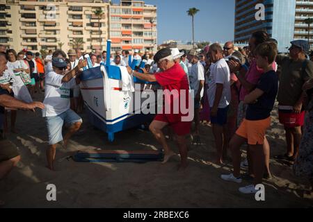 Malaga, Spanien. 09. Juli 2023. Einheimische werden gesehen, wie sie ein Fischerboot „jabega“) in Richtung Meer schieben, während sie an der Ausstellung „La Tirada del Copo“ am Strand von Los Boliches teilnehmen. Jedes Jahr feiern die Einheimischen in Fuengirola eine alte Fischereitradition, bekannt als „La Tirada del Copo“, um die Fähigkeiten und den Handel von Seeleuten und Fischern beim Fang von Fischen im Meer zu demonstrieren. Wie es die Tradition vorschreibt, werfen Seeleute während der „La Tirada del Copo“ Netze ins Meer, die einen Halbkreis bilden, während andere die Netze zum Strand ziehen, um alle Fische zu fangen. Kredit: SOPA Images Limited/Alamy Live News Stockfoto