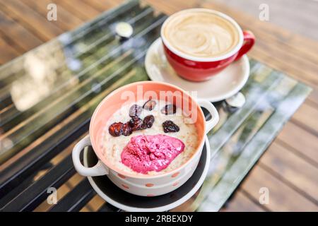 Frühstück mit frisch zubereitetem Haferbrei, serviert mit trockener Kirsche und Erdbeersorbet in der Schüssel. Müsli, köstliches Frühstück, Diät-Frühstück. Eine Tasse Stockfoto