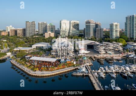 Die Bars, Restaurants und der Yachthafen am Wasser in Coconut Grove, Miami, Florida, sind aus der Vogelperspektive zu sehen. Die Skyline im Hintergrund an einem ruhigen, klaren, sonnigen Sommermorgen. Stockfoto