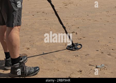 Ein Mann mit Metalldetektor, der den Strand scannt, um einen Schatz zu finden Stockfoto