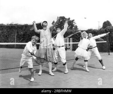 Los Angeles, Kalifornien: ca. 1917. Mai Sutton Bundy gewann die USA Tennis Open 1904 und 1905 war die erste amerikanische Frau, die Wimbledon gewann. Hier lehrt sie ihren vier Kindern die Feinheiten des Sports. Stockfoto