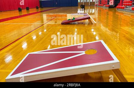 Seitlicher Blick auf hausgemachte Cornhole Spielbretter und Bowling in einem Fitnessraum für den Gymnasium. Stockfoto