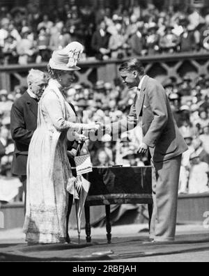 London, England: 1926 King George V und Queen Mary bei den Jubilee Lawn Tennis Championships in Wimbledon. Der König überreichte Werbespots an ehemalige Champions, und Königin Mary begrüßt Vincent Richards aus den Vereinigten Staaten, den Doppelgewinner im Jahr 1924. Stockfoto