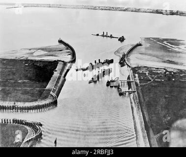 Zeebrugge, Belgien: April 1918 ein Blick aus der Vogelperspektive auf den Eingang zum Brügge-Kanal in Zeebrugge mit den gesunkenen britischen Schiffen Thetis, Intrepid und Iphigenia. Es war ein Versuch, den Hafen zu blockieren, der von der deutschen Marine als Stützpunkt für ihre U-Boote genutzt wurde, aber weitgehend gescheitert ist. Rechts ist eine Dredge zu sehen, die einen Kanal freimacht, den die Deutschen bei Flut noch benutzen können. Stockfoto