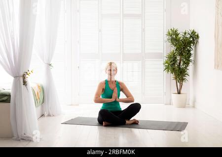 Wellnesskonzept. Porträt Einer Schönen, Erzieherischen Frau, Die Zu Hause Yoga Praktiziert Stockfoto