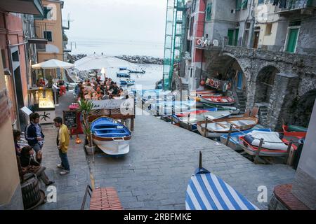 Riomaggiore Italien - 26 2011. April; Straße gesäumt mit traditionellen Booten und Restaurants auf der Cinque Terre. Stockfoto