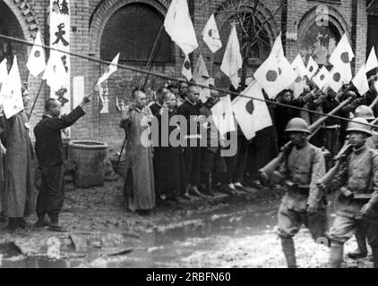 Nordchina Front: ca. 1938. Japanische Truppen werden von chinesischen Einwohnern mit Flaggen begrüßt, während sie von Tienstin nach Westen in Richtung Pao-ting, der Hauptstadt von Mopei, fahren. Stockfoto