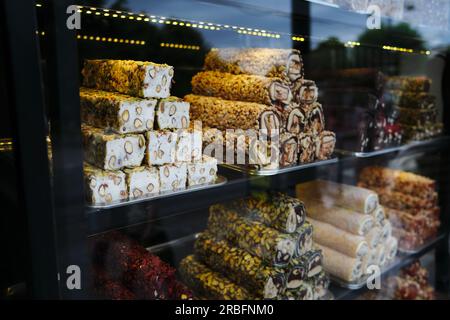 Türkische Köstlichkeiten verschiedener Arten - Schokolade, Obst, mit Pistazien - werden auf einem Schaufenster in Istanbul gestapelt Stockfoto