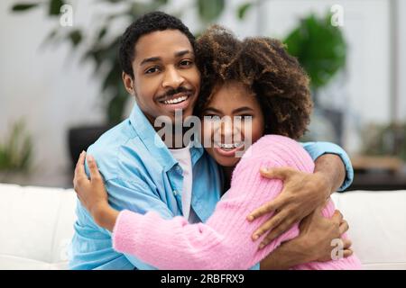 Porträt von einem liebenden, glücklichen, jungen schwarzen Paar, das umarmt Stockfoto
