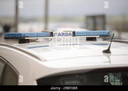 Garda-Schild und blaue Lichter an einem Garda-Auto. Stockfoto