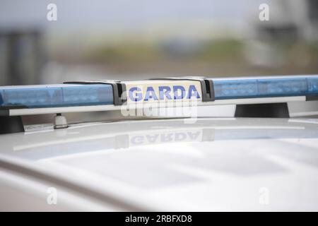 Garda-Schild und blaue Lichter an einem Garda-Auto. Stockfoto