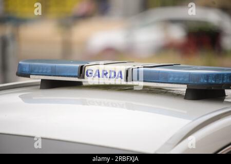 Garda-Schild und blaue Lichter an einem Garda-Auto. Stockfoto