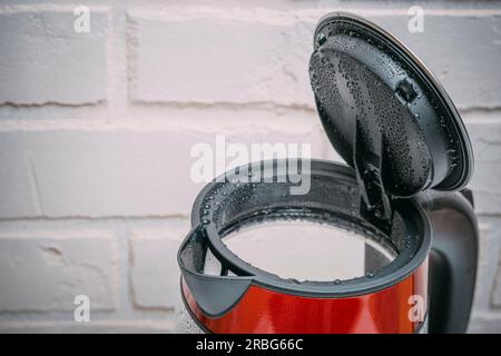 Elektrischer Wasserkocher aus Glas mit offenem Deckel und weißer Hintergrundansicht von oben. Stockfoto