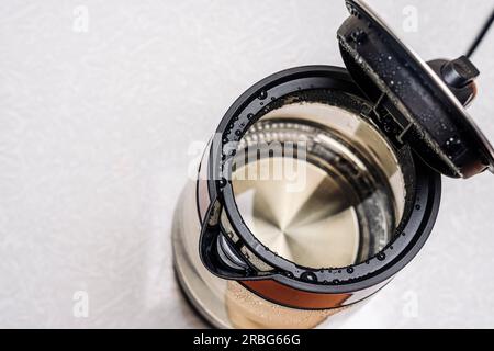 Elektrischer Wasserkocher aus Glas mit offenem Deckel und weißer Hintergrundansicht von oben. Stockfoto