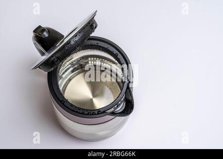 Elektrischer Wasserkocher aus Glas mit offenem Deckel und weißer Hintergrundansicht von oben. Stockfoto