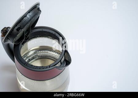 Elektrischer Wasserkocher aus Glas mit offenem Deckel und weißer Hintergrundansicht von oben. Stockfoto