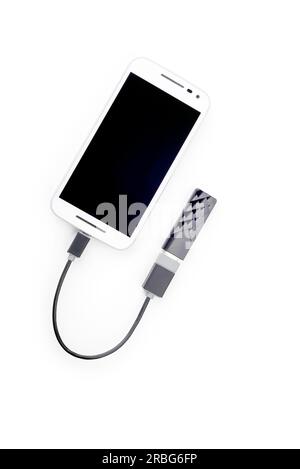 White Smartphone zu einem schwarzen USB-Schlüssel mit einem OTG-Kabel angeschlossen. Auf weissem Hintergrund Stockfoto