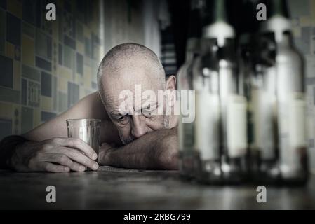 Ein verzweifelter Mann fällt in Depressionen und wird alkoholisch und unglücklich. Seine sucht führt ihn in einen Zustand der Einsamkeit und Armut. Er hat keine Stockfoto