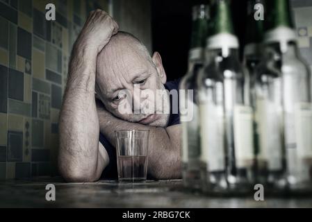 Ein verzweifelter Mann fällt in Depressionen und wird alkoholisch und unglücklich. Seine sucht führt ihn in einen Zustand der Einsamkeit und Armut. Er hat keine Stockfoto