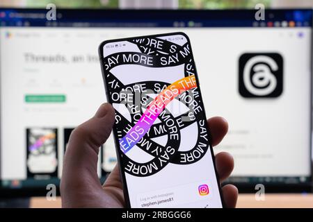 Die Hand eines Mannes, der ein Smartphone hält und den Startbildschirm für Threads und sein Logo anzeigt, eine Instagram-App für soziale Medien von Meta. UK Stockfoto