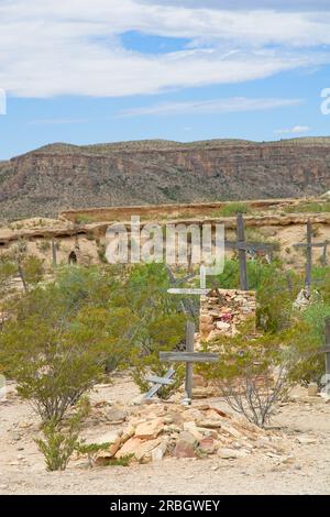 Grabstätten auf dem Terlingua Friedhof 1902 außerhalb der Geisterstadt Chisos Mining Company mit erodierendem bergkamm dahinter Stockfoto