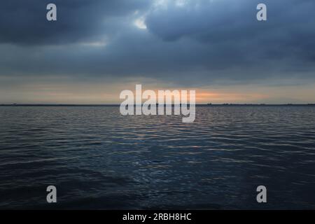 Bewölkter Sonnenuntergang mit Schiffen vor Anker in Manila Bay, Philippinen Stockfoto