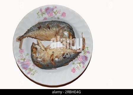 Zwei frittierte Makrelen werden abwechselnd mit Köpfen und Schwänzen auf einem Teller platziert. Stockfoto